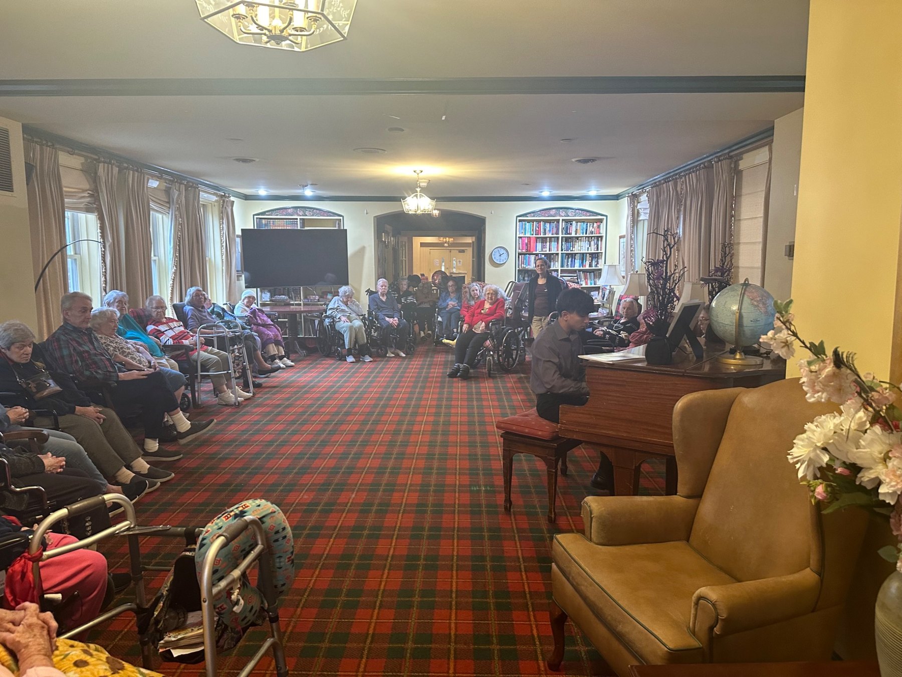 A large audience seated at a senior living performance